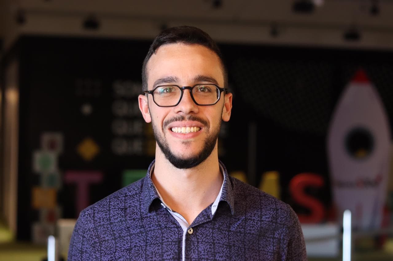 Portrait of Renan Oliveira, founder of Zenos Tech, with a colored background.